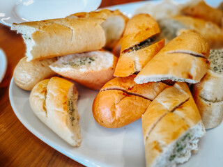 A plate of sliced garlic bread filled with herb butter, showcasing its golden crust and soft interior. A delicious appetizer or side dish perfect for any meal.