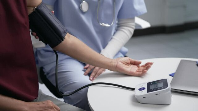 Medical professional checking arterial pressure with digital device, examining elderly patient's cardiovascular condition during clinical health screening