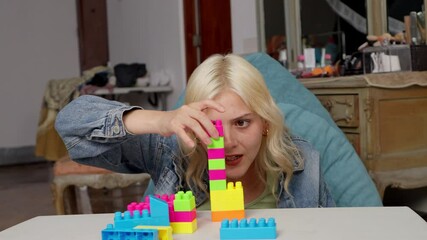 Influencer building toy tower while explaining creativity - Powered by Adobe