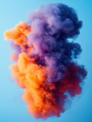 Naklejka premium Ethereal cloud of vibrant orange and purple smoke against a serene light blue backdrop creating a mesmerizing visual spectacle with soft texture