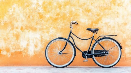 Naklejka premium A classic cruiser bike leaning against a soft orange stucco wall