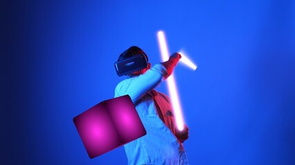 Gamer playing game while holding glowing sword and wearing VR glasses. Attractive male model...