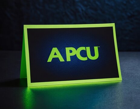 A striking green and black display card featuring the letters 'APCU' in bold typography.