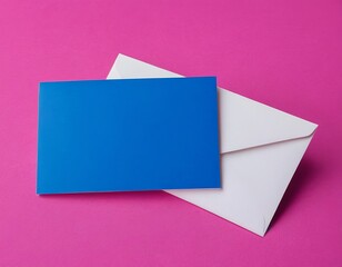 A vibrant blue card lies atop a white envelope against a bright pink background.