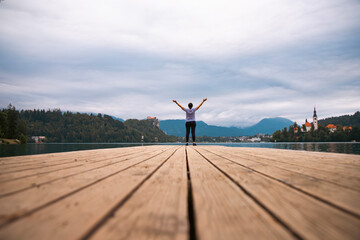 Woman standing on wooden deck, pier at Bled lake, Slovenia