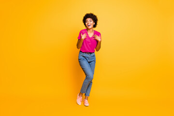 Full length body size photo of cheerful curly wavy black lady wearing jeans denim unable to believe in being chosen excited rejoicing isolated over yellow vivid color background