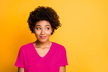 Photo of amazing dark skin lady looking side empty space with cunning smile wear orange v neck...