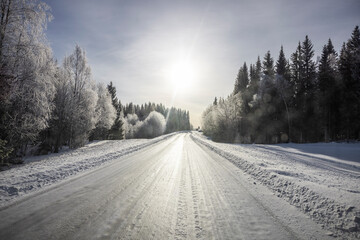Verschneite Landstrasse mit Schneefahrbahn im  Winter
