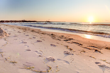 A beach with a sunset in the background