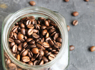 Fototapeta premium Arabica coffee beans in a glass jar on a dark table