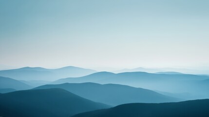 Gentle, rolling mist shrouds distant blue mountains in layers, creating a mysterious, serene landscape with a quiet, contemplative atmosphere.