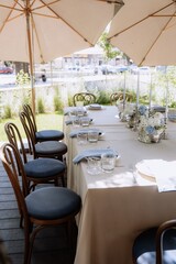 Seating for guests at a table in a restaurant on a terrace in summer. Sunlight and dishes on the table luxury decor