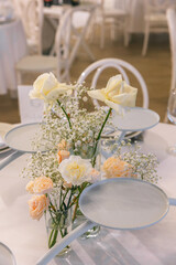 Table decoration for guests at the event celebration. Rose and dishes on the table