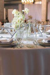 Table decoration for guests at the event celebration. Rose and dishes on the table