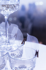 Pyramid of wine glasses on a table in a restaurant under lights. Luxury catering for a celebration