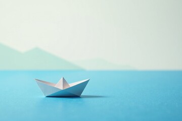 Obraz premium A small paper boat floats serenely on a tranquil blue surface, a gentle landscape softly blurred in the background, evoking a sense of calm and hopeful journey.