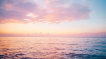 Fototapeta premium A serene pastel sunset over a calm sea, with softly streaked clouds reflecting gentle hues on the tranquil waters.