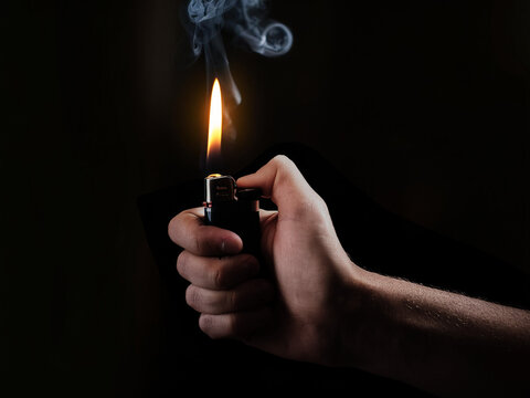 hand holding lighter in the dark