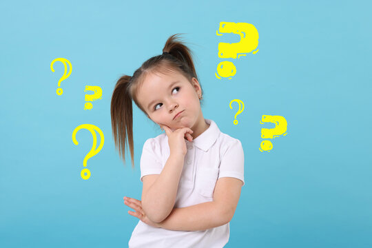 Confused little girl on light blue background. Yellow question marks near child