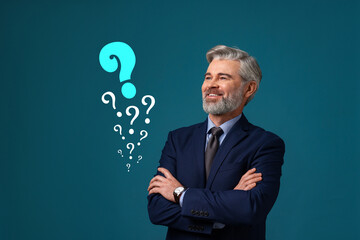 Happy businessman looking at question marks on teal color background