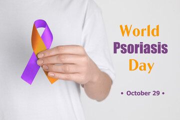 World Psoriasis Day (October, 29). Woman holding orange-orchid awareness ribbon on white...
