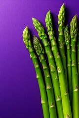 Organic green asparagus arranged on a deep purple surface, Copy space.