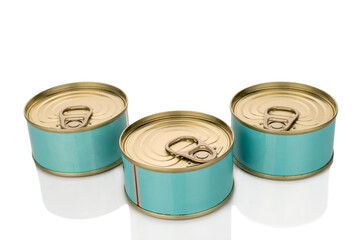 Three metal cans of tuna, close-up, isolated on a white background.