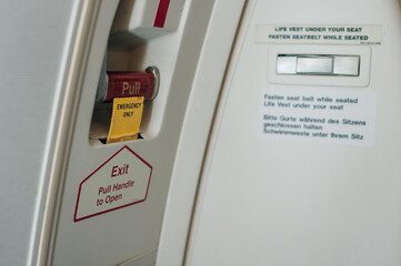a closed Passenger airplane entrance door - inside view - with the inflatable emergency evacuation...