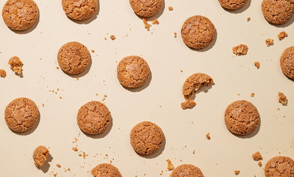 Flat lay of amaretti cookies on beige background with shadow.