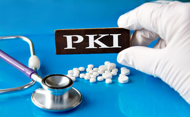 Cubes with the abbreviation PKI in the hand of a doctor.