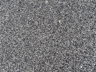 Close-up of textured asphalt surface with gray and white pebbles