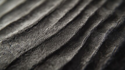 A close-up macro shot of a textured concrete wall with fine parallel lines, highlighting its rough surface details