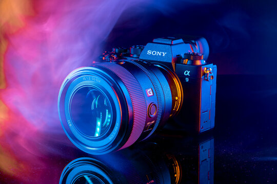 Milan, Italy - February 26, 2025: close up on a Sony A9 II Mirrorless camera with Sony A9 II with FE 50mm f/1.2 GM on black background enveloped with smoke.