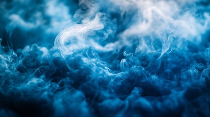 Obraz premium Soft tendrils of ethereal blue smoke dance through the air, creating a mesmerizing display of abstract forms. The low light enhances the dreamlike quality of this captivating moment