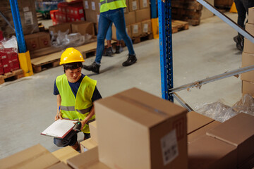 Female Asian warehouse worker making a list of goods