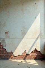 Sunlit Wall with Exposed Brickwork and Flaking Plaster Reveals a Sense of Age and Decay