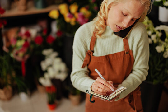Florist writing order in a flower shop