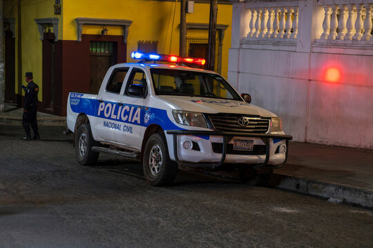 Sign in Spanish Civic National Police on the truck with blue and siren lights on parked on the street at the main park of a tourist town.	