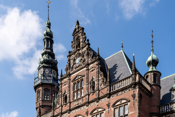 Obraz premium Academy Building of the University of Groningen with Ornate Facade and Clock Tower under a Blue Sky
