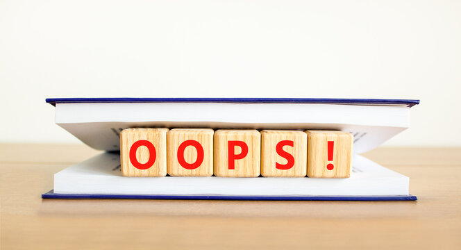 Oops symbol. Concept word Oops on beautiful wooden blocks in book. Beautiful wooden table white background. Business lifestyle oops concept. Copy space.