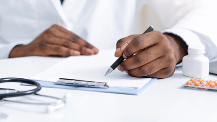 Fototapeta premium Close up of black doctor prescribing pills to patient, clinic interior