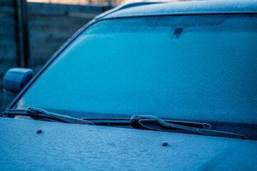 Black car covered in frost on an early winter morning. Frosty morning outside the city. Car windows iced over