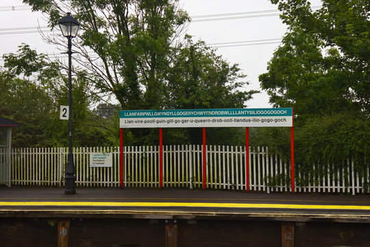 Wales, Isle of Anglesey, Llanfairpwllgwyngyll - July 11, 2024: Sign at the railway station with a lengthened form of the community name.