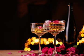 A coupe glass filled with champagne and floating pink rose petals, creating an elegant and romantic atmosphere.
