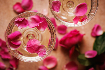Vintage-style glass with golden champagne and floating rose petals, evoking a cozy and luxurious...