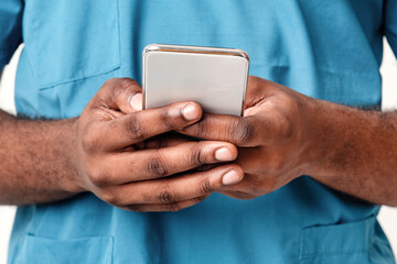 Close up of African American man therapist using smartphone, chatting with patients during flu epidemic