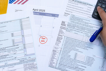 Person filling out the tax forms, with the calculator for the 2025 tax return and calendar with the...