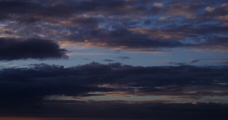 Thick dark clouds cover the sky at sunset. A beautiful view of the evening cloudy sky with pink reflections of the setting sun. Video in 4k, red komodo