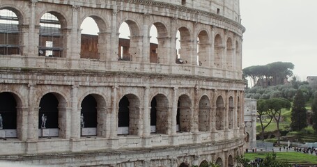 Fototapeta premium Close-up of part of the Coliseum on a sunny warm day. Italy tourist attraction, Rome. Many tourists at the foot of the monument of architecture. Video in 4k, red komodo