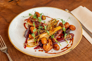 Gourmet plated dish with roasted vegetables and meat

